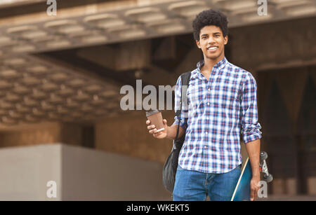 Attractive young guy walking in the city drinking takeaway coffee Stock Photo