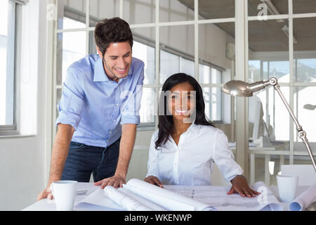 Architects working hard on blueprints in the office Stock Photo