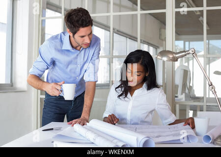 Architects drinking coffee while working in the office Stock Photo