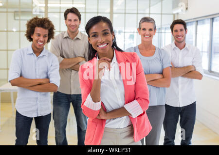 Well dressed workers with arms folded smiling at camera in the office Stock Photo