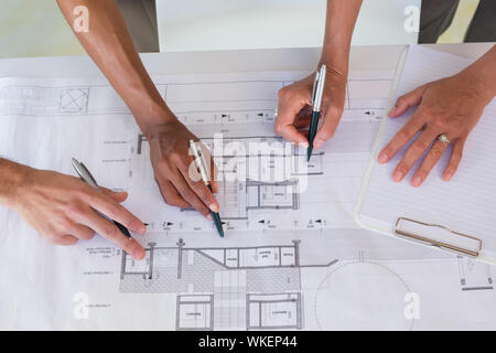 Team of architects going over blueprints in the office Stock Photo