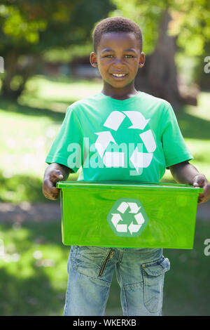 Young boy in recycling tshirt holding box on a sunny day Stock Photo