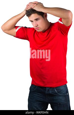 Disappointed football fan in red on white background Stock Photo