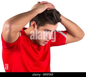 Disappointed football fan in red on white background Stock Photo