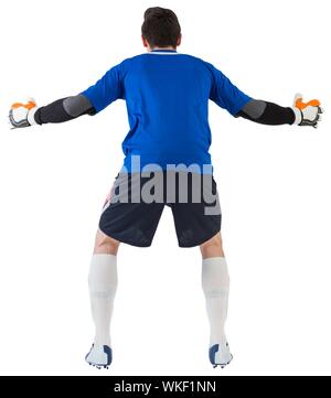 Goalkeeper in blue ready to save on white background Stock Photo