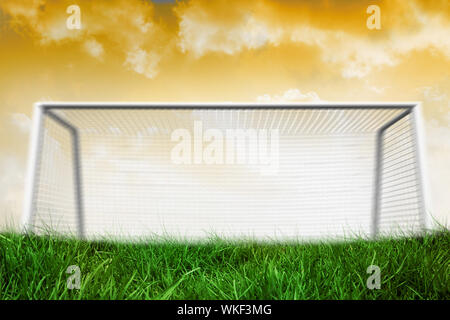 Digitally generated goalpost on grass under yellow sky Stock Photo