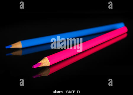 Group of two whole colored pencil cold gamma isolated on black glass Stock Photo