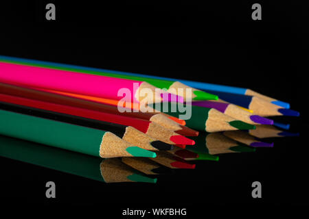 Group of twelve whole colored pencil isolated on black glass Stock Photo