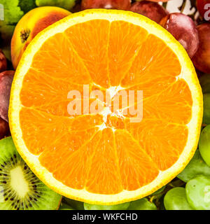 Fresh Orange on a background of different fruits and grapes Stock Photo