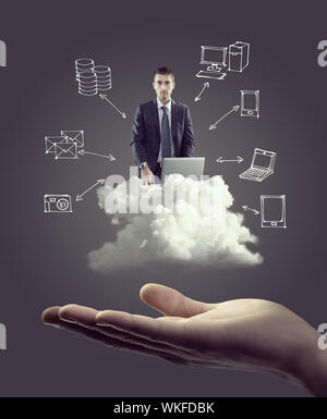 Businessman with laptop on cloud with hand drawn technology icons and hand. Stock Photo