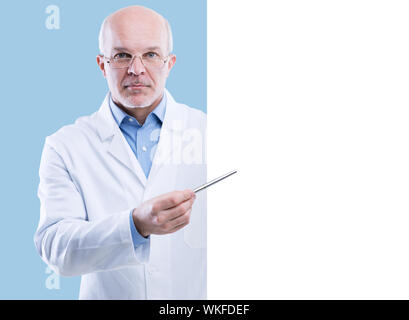 Senior doctor holding a big white sign and pointing with a pen, blank copyspace. Stock Photo