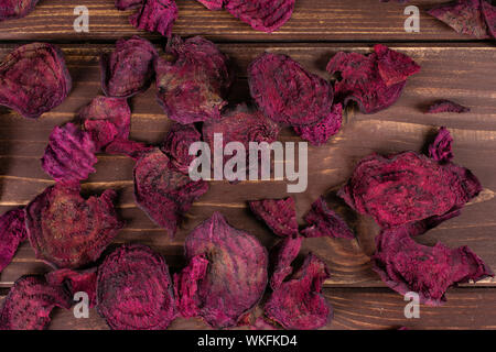 Lot of slices of dried red beetroot flatlay on brown wood Stock Photo