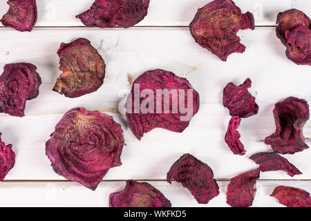 Lot of slices of dried red beetroot flatlay on white wood Stock Photo