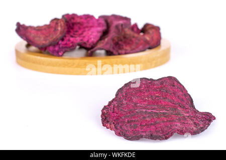 Group of six slices of dried red beetroot on bamboo coaster isolated on white background Stock Photo
