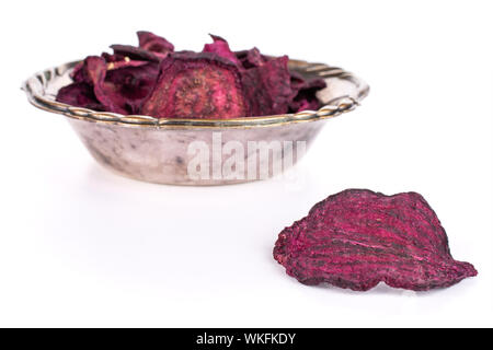 Lot of slices of dried red beetroot one is in the front and the rest is in metal bowl isolated on white background Stock Photo