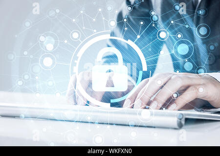 Close up of female hands using computer keyboard and lock icon on screen Stock Photo
