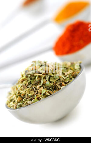 Assorted spices in metal measuring spoons on white background Stock Photo