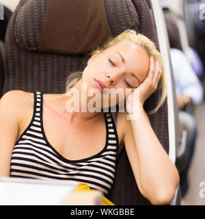 Lady traveling napping on a train. Stock Photo