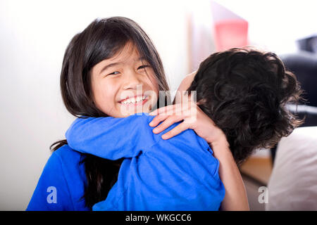 Big sister taking care of her disabled little brother Stock Photo