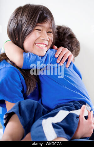 Big sister taking care of her disabled little brother Stock Photo