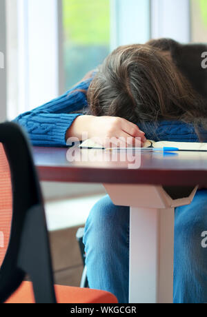 Young college or high school student asleep on table Stock Photo