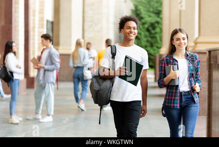 Multiracial students walking in university hall outdoors Stock Photo