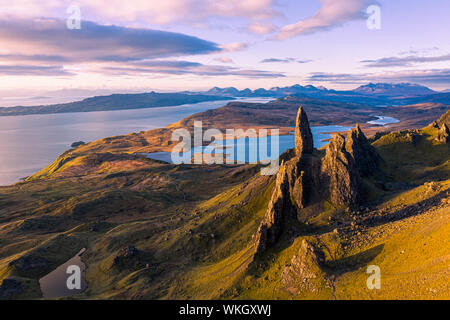 An aerial view from the Storr of the Old Man of Storr with the Black Cuillin mountains in the distance. The sun has only just risen above the horizon Stock Photo