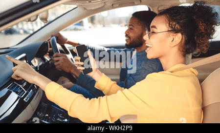 Afro couple driving car and using gps navigator Stock Photo