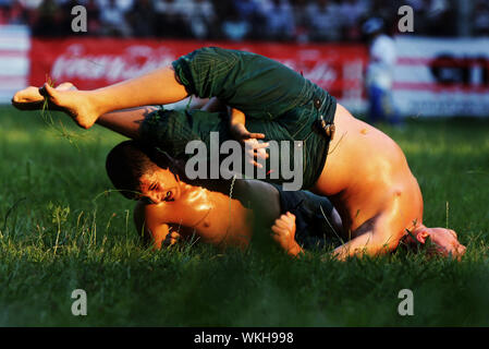 A young wrestler is tossed onto his back during competition at the Kirkpinar Turkish Oil Wrestling Festival in Edirne in Turkey. Stock Photo