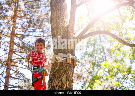 Boy on the rope park line attached to cable Stock Photo