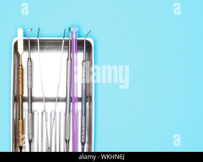 Dental instrument in tray on blue background with copy space. Dental care concept Stock Photo