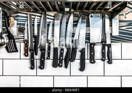 Kitchen knives on a magnetic bar holder on the wall Stock Photo