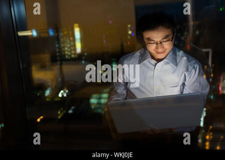 Asian man work at night in the office. Stock Photo