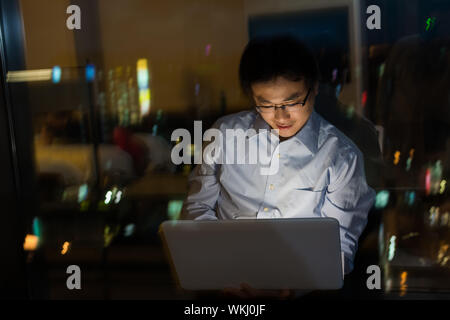 Asian man work at night in the office. Stock Photo