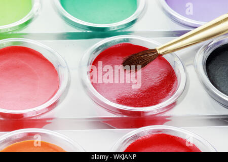 Abstract of new unused palette of children's multicolor watercolor paints with paint brush. Stock Photo