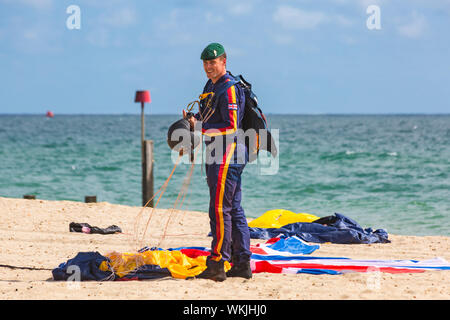 Member of Tigers Freefall Parachute Team collecting up parachute after descending onto the beach at Bournemouth Air Festival, Dorset UK in August 2019 Stock Photo