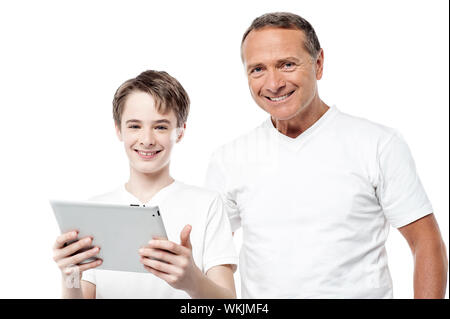 Father and son posing to camera holding tablet pc over white Stock Photo