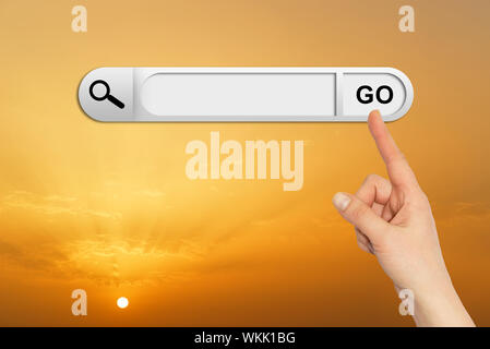 Human hand indicates the search bar in browser. Sunset or sunrise on background Stock Photo