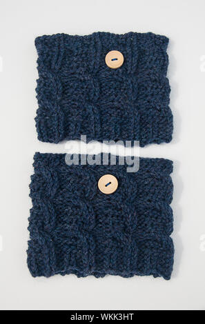 Blue knit wool boot toppers fashion accessory isolated on a white background.  This fiber art has light colored buttons on the cuffs. Stock Photo