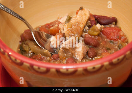 Bowl of chili verde with pork chunky soup in a bowl with a spoon.  Hearty homemade stew food. Stock Photo