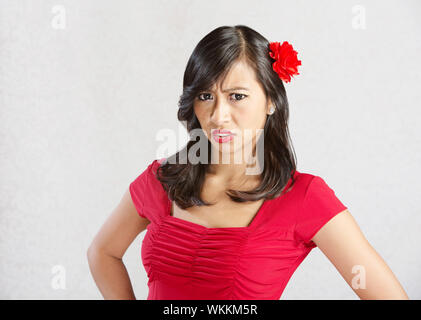Single disgusted Asian female in red dress Stock Photo