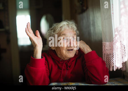 Emotional elderly woman in his home. Stock Photo