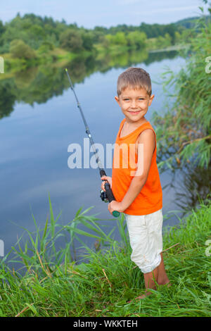 Summer vacation - Photo of little boy fishing on the river. Stock Photo