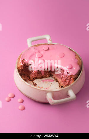 Homemade pink brownie with Ruby chocolate on pink background. Red Belgian chocolate cake dessert. Eaten sweets. Pink melted chocolate on fudge cake. Stock Photo