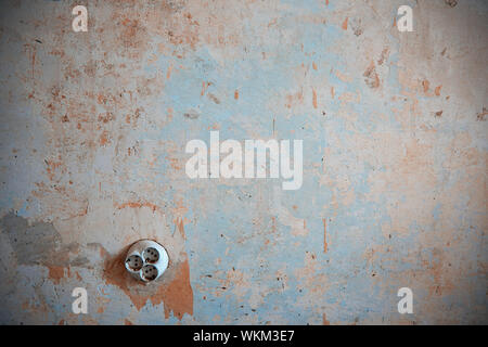 Old electric outlet on a rusty wall. Horizontal photo Stock Photo