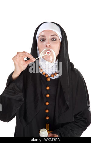 Nun blowing out a huge bubble through a plastic wand Stock Photo