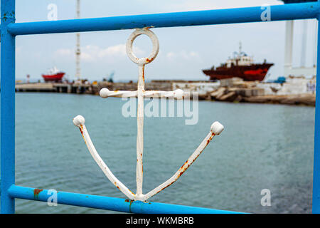 Symbol of the sea anchor against the background of the old ship. Stock Photo