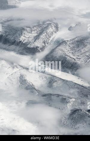 View from the plane on glacier, snow covered landscape with mountains from bird's eye view, Greenland Stock Photo