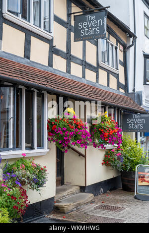 Floral hanging baskets outside The Severn Stars Inn. 16th century timber framed period building. Ledbury Herefordshire. England Stock Photo