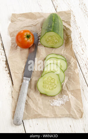 sliced ​​cucumber, salt and a tomato on brown paper Stock Photo